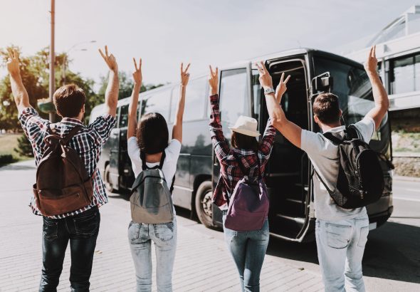 Young People having Fun in front of Tour Bus