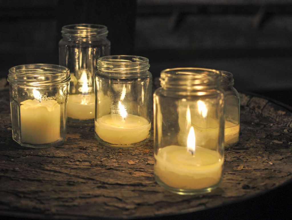 lit-candles-in-mason-jars-on-table-681966283-5c47b57a46e0fb0001b89498